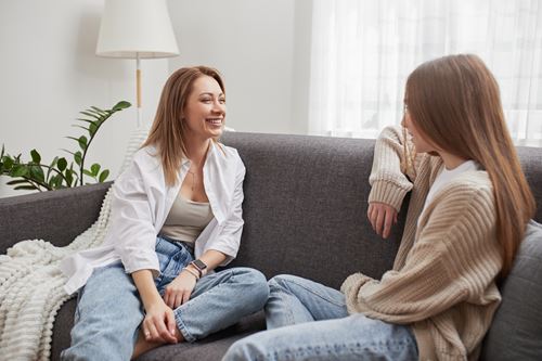 Support worker talking to young person on a sofa