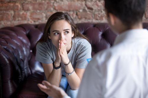 Young person sat in thought whilst talking to support worker