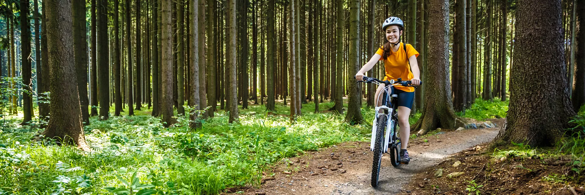 Young person riding bike in forest
